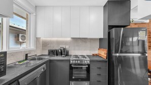 Una cocina compacta con estufa a gas, horno y refrigerador integrado.