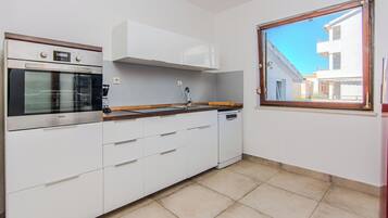 Een koelkast met diepvriezer, een microgolfoven, een oven, een kookplaat