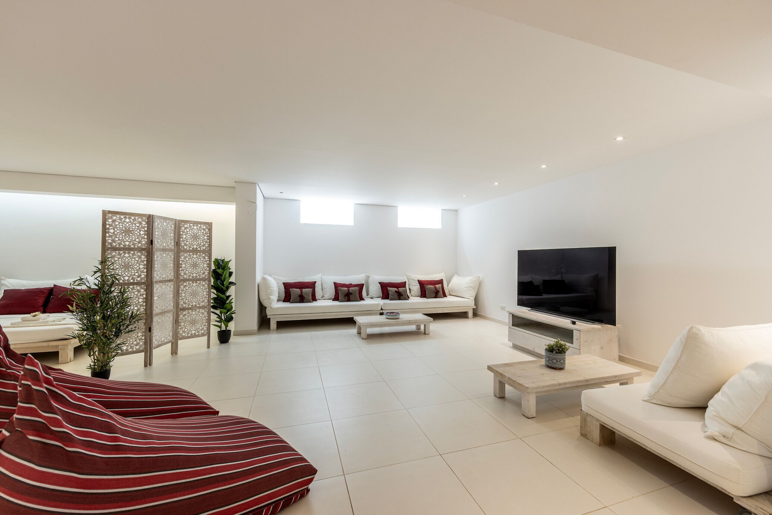 A modern living room with a sofa set, a coffee table, a TV, and a decorative partition.