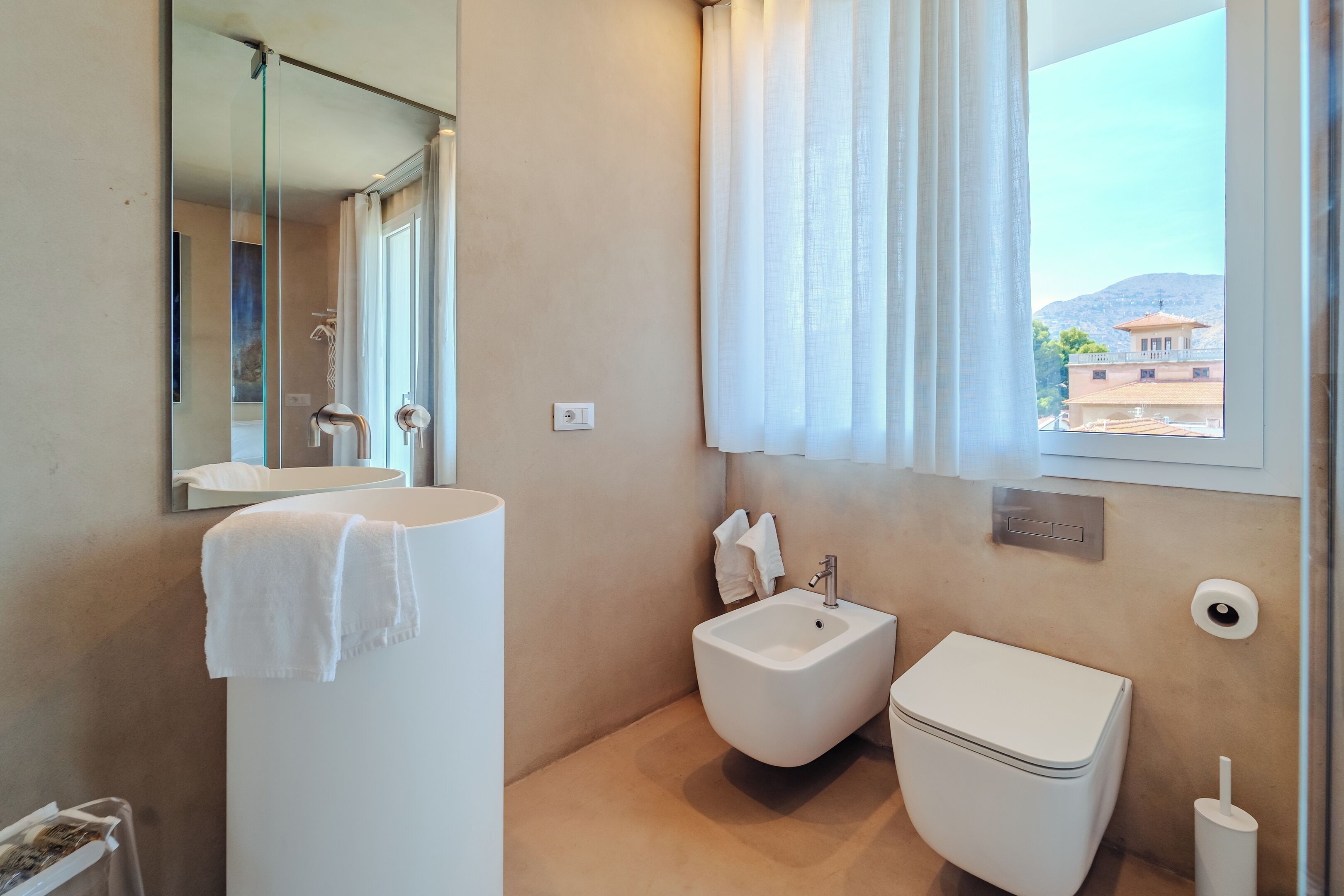 Un bany modern amb bidet, vàter i rentapel.