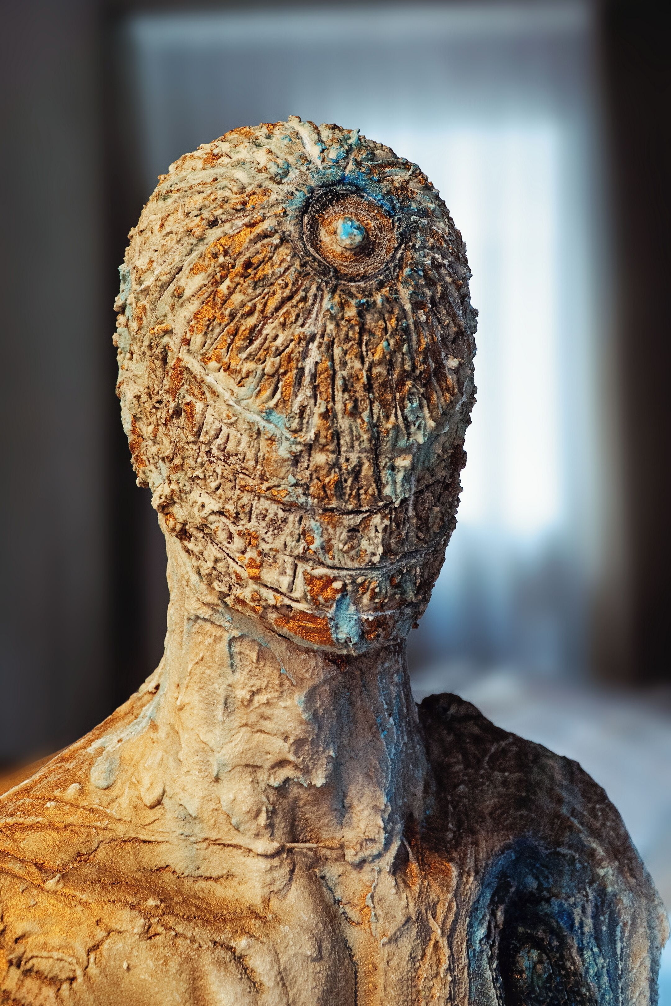 A sculpture with a textured surface and a central circular feature.