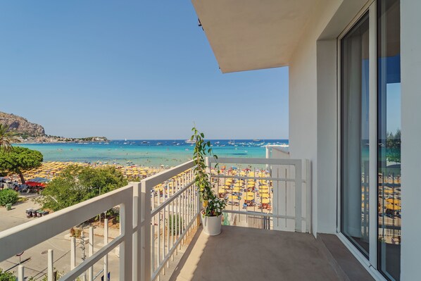 Un balcon avec vue sur une plage et la mer.