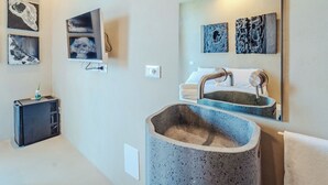A modern bathroom with a stone sink, a mirror, and artwork on the walls. - Hybrid Icon Rooms Gallery (Palermo)