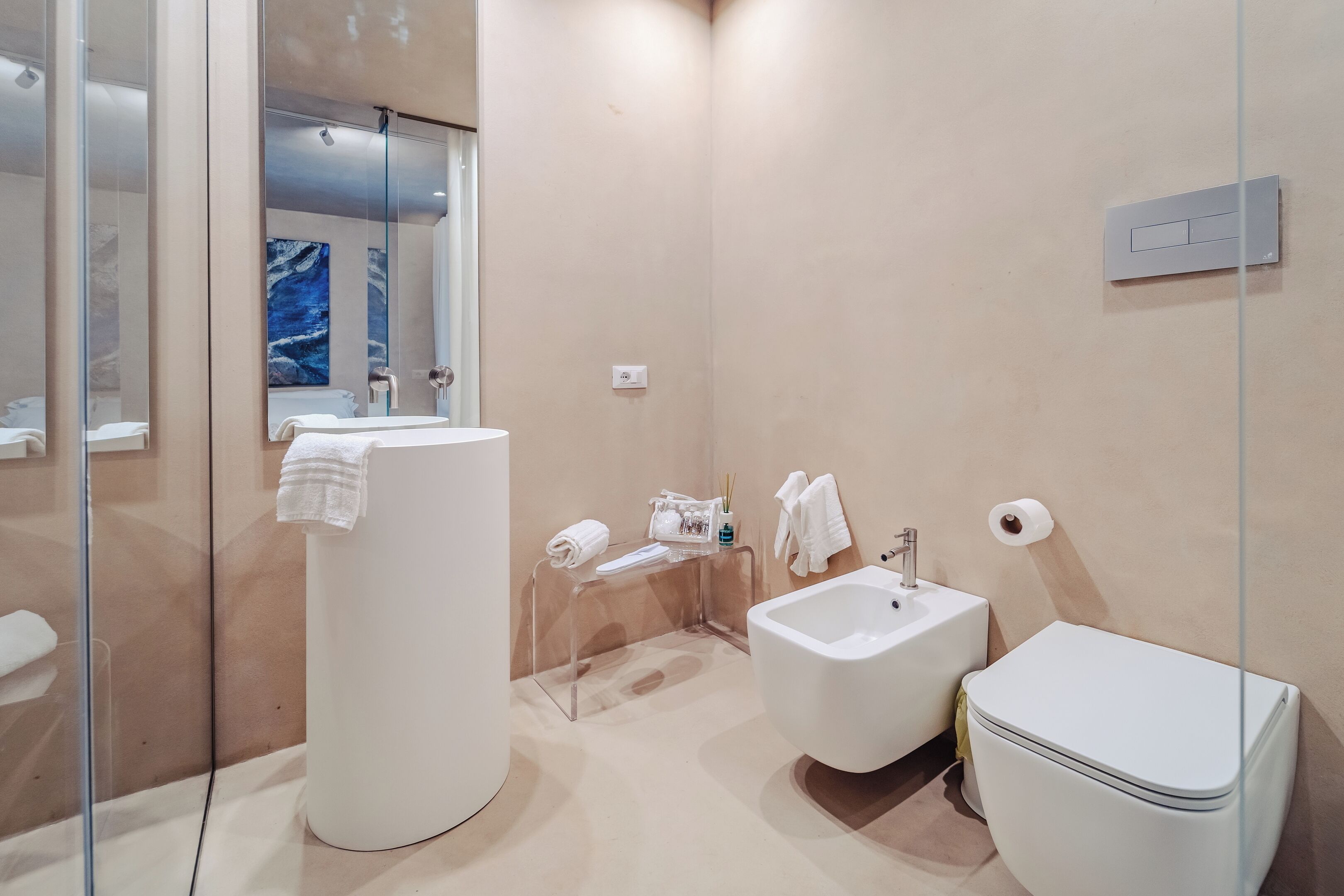 Un baño moderno con inodoro, bidé y lavamanos.