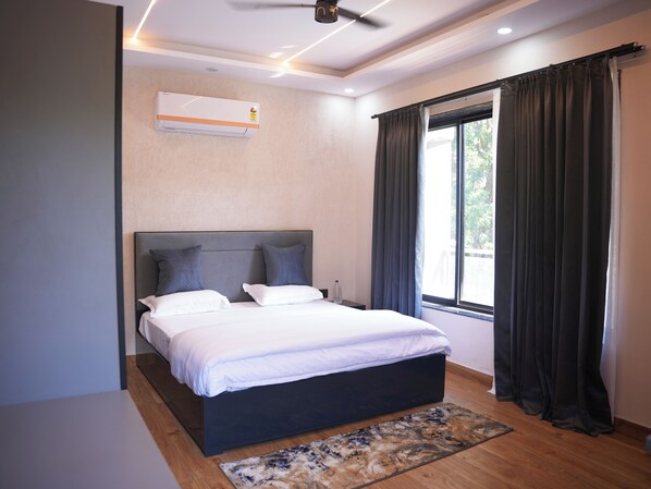 A modern bedroom with a large bed, a ceiling fan, and a window with curtains. - HomeGround (Gurugram)