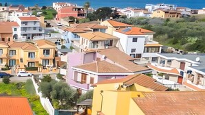 Un quartier résidentiel avec des immeubles à plusieurs étages, une route bien visible et une vue dégagée sur la mer.