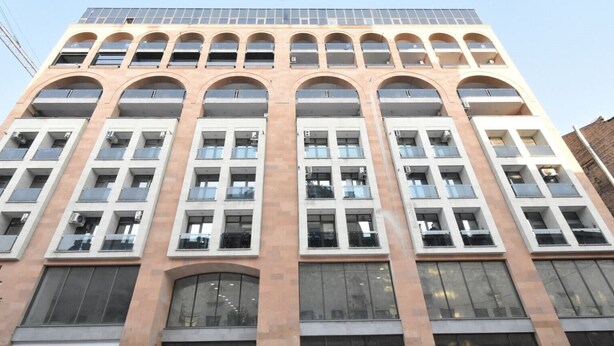 A multi-story building with a symmetrical facade, large windows, and a central arched entrance. - Apartment by Luxe Group DI412 (Yerevan)