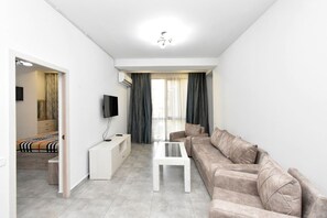 Eenvoudig appartement | Woonruimte | Een 50-inch flatscreentelevisie met kabelzenders