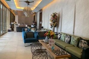 A hotel lobby with a reception desk, seating area, and a chandelier. - Thailand Pattaya Center Sea Seascape Apartment (Pattaya)