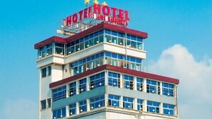 Un edificio de hotel de varios pisos con un letrero grande en la parte superior que dice "HOTEL".