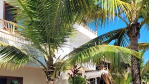 A white building with a balcony, a pool, and palm trees. - SuBanda Boutique Hotel (Makunduchi)