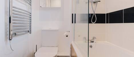 A modern bathroom with a toilet, a glass-enclosed shower, and a bathtub.
