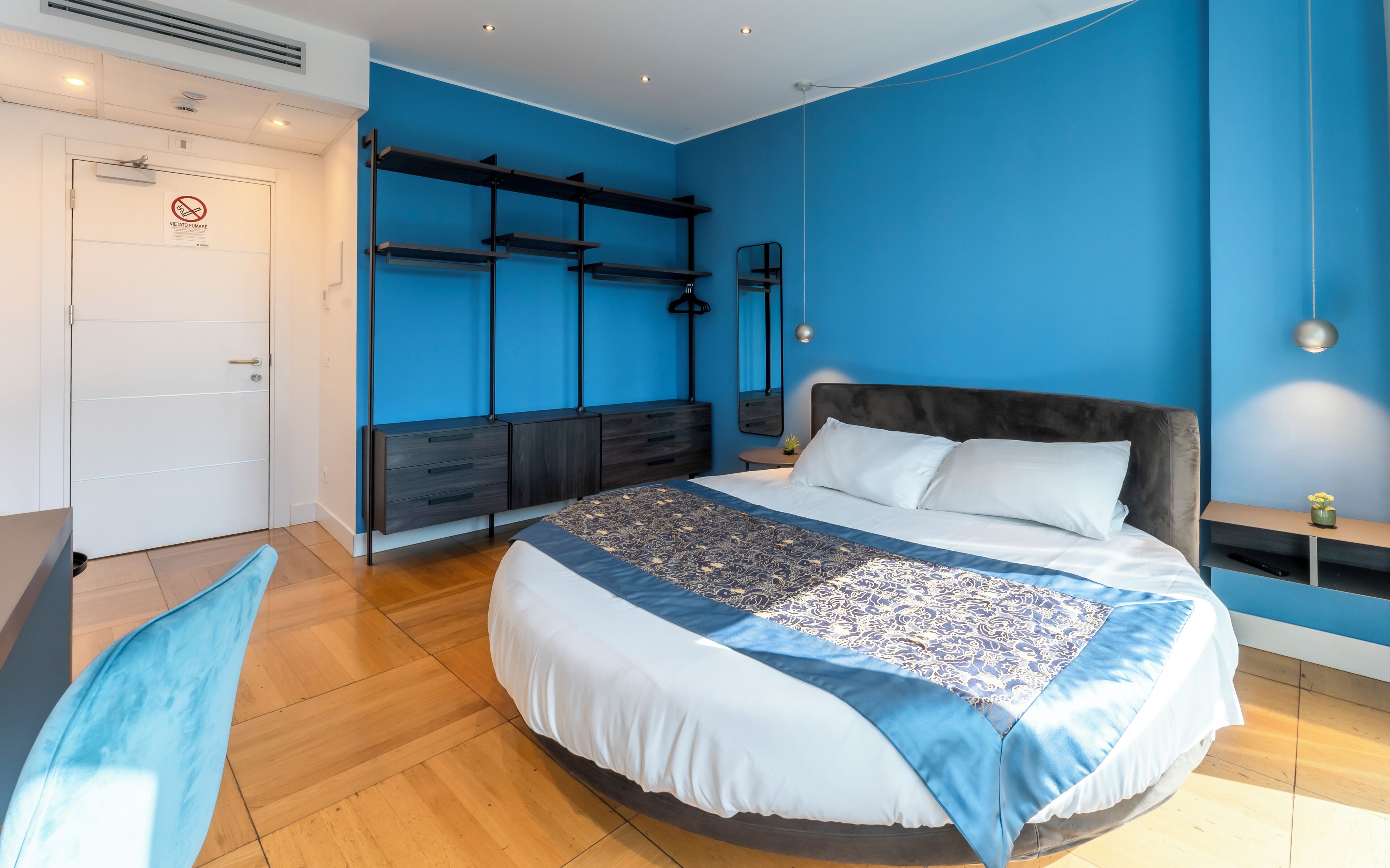 Une chambre à coucher moderne avec un grand lit, des étagères intégrées, un bureau et une armoire.