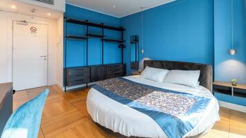 Une chambre à coucher moderne avec un grand lit, des étagères intégrées, un bureau et une armoire.