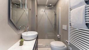 A modern bathroom with a glass-enclosed shower, a white sink, and a toilet. - La Dimora di Missori (Milan)