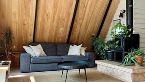 Un salon moderne de style industriel, avec un canapé, une table basse et des plantes en pot.