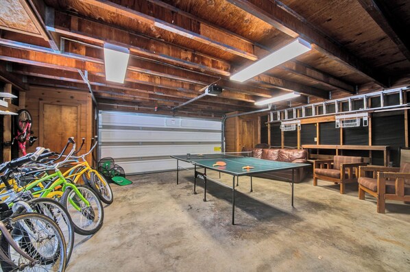A spacious indoor area with a ping pong table, wooden benches, and bicycles. - Yellow Pine 10 - Family Friendly, Hot Tub, Pets Welcome, Sharc Passes (Sunriver)