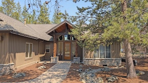 A rustic cabin with a stone foundation, wooden siding, and a sloped roof. - Verdin 6 - Lovely Lodge Style home, A/C, Private Hot Tub (Sunriver)