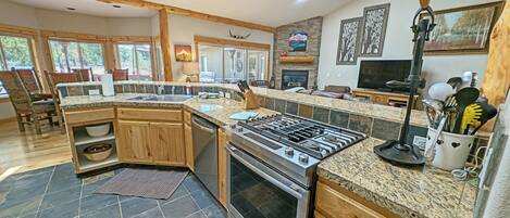 A spacious kitchen with granite countertops, a built-in oven, and a large island.