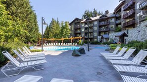 A resort with a pool area, lounge chairs, and a multi-story building with balconies.