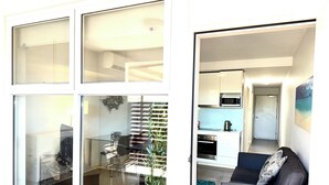 A modern interior with a dining area, kitchen, and living space. - The Padbury Suites-Premium City Apartment (Bulgarra)
