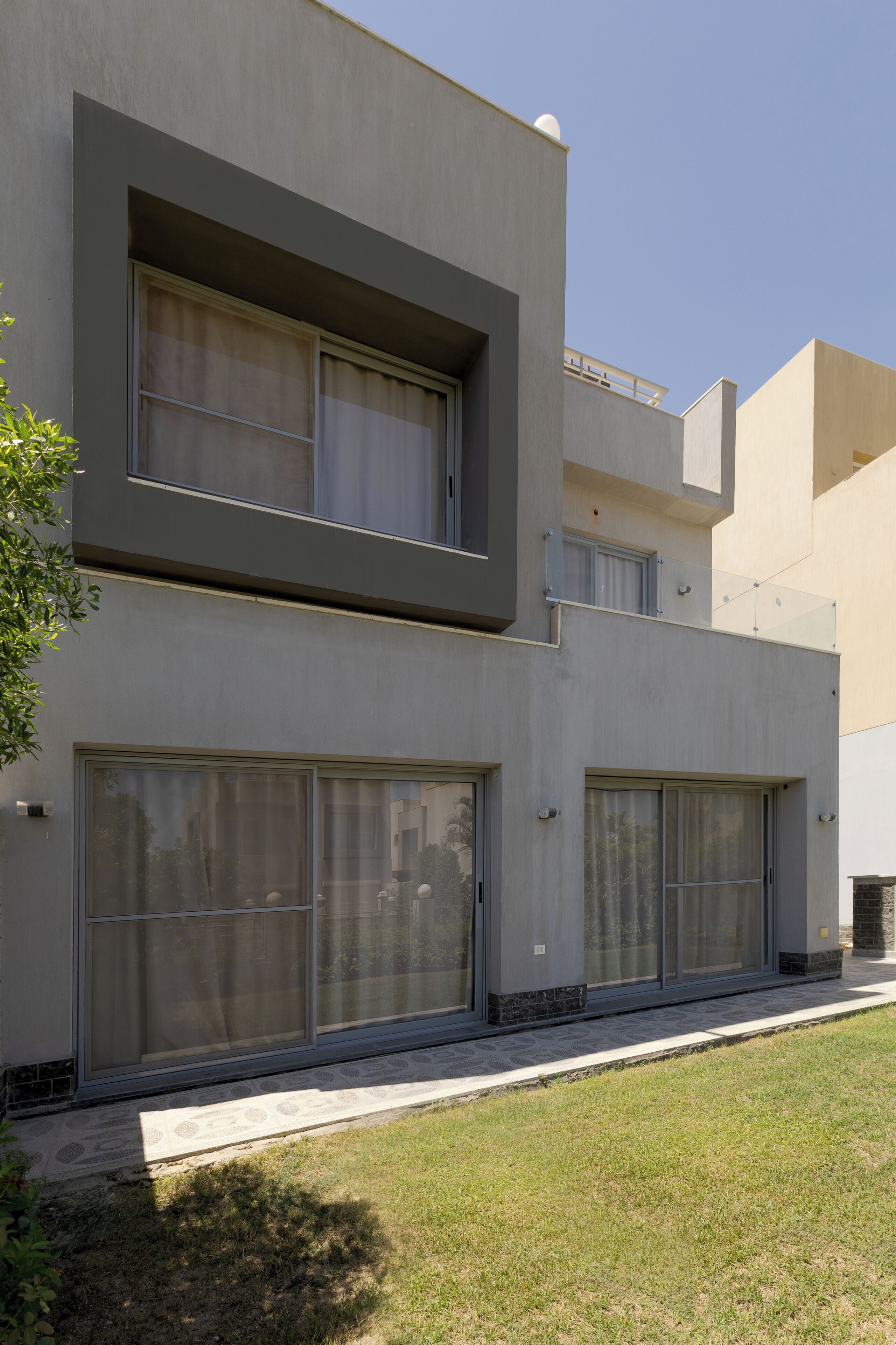 A modern two-story building with large windows and a flat roof.