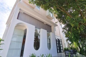 Un edificio moderno de dos pisos con ventanas amplias y un balcón.