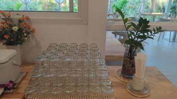 A table with multiple clear glasses and a potted plant.