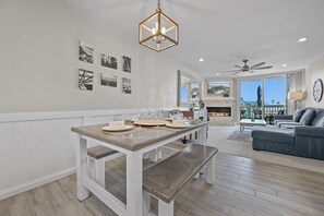 A spacious living room with a dining area, a fireplace, and a balcony with a view. - Coastal Luxury! Oceanview 1-Bedroom Retreat at North Coast Village C312 (Oceanside)