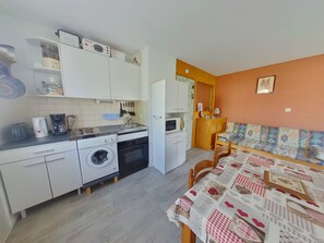 A compact kitchen with a washing machine, microwave, and coffee maker. - Cozy apartment in Les Rousses with terrace, near activities (Les Rousses)