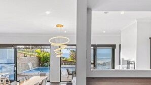 Un intérieur moderne comprenant un coin repas, une piscine et de grandes fenêtres donnant sur l’extérieur.