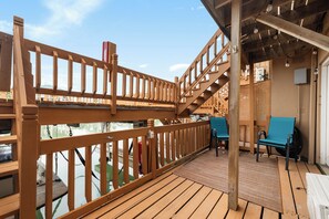 A wooden deck with a railing, a staircase, and a seating area with chairs. - Fisherman's Retreat-Boat Slip & Fishing on Deck (Port Isabel)