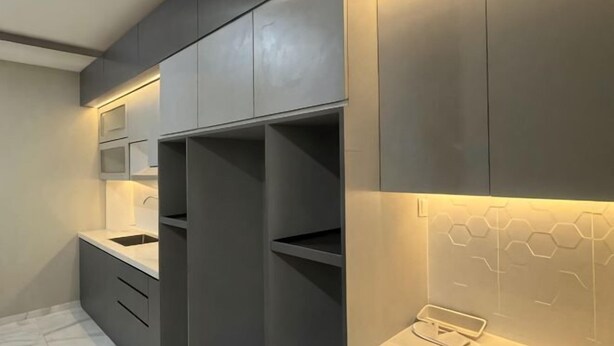 Une cuisine moderne dotée d’appareils électroménagers intégrés, d’un plan de travail et d’un revêtement mural en forme d’hexagone.