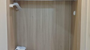Une pièce en bois avec un porte-serviettes en métal et une serviette pliée posée sur le sol.