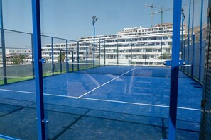 An indoor tennis court with a blue surface, surrounded by blue fencing. - Resort Seascape Villa 8 by Bookaparadise (Finestrat)