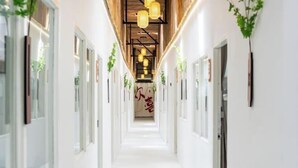 A modern hotel corridor with white walls, wooden ceiling beams, and hanging pendant lights. - ZJ House(Phuket Town) (Phuket)
