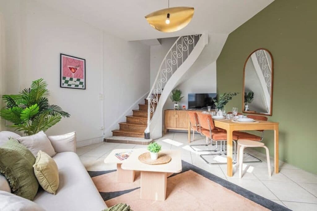 Een moderne woonkamer met een bank, salontafel en een eethoek met stoelen en een tafel.