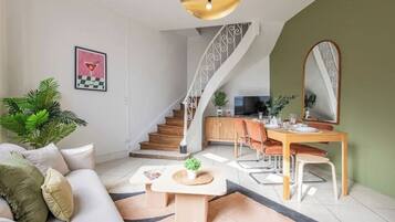 Een moderne woonkamer met een bank, salontafel en een eethoek met stoelen en een tafel.