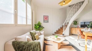 Ein modernes Wohnzimmer mit einer Couch, einem Couchtisch und einer Treppe.