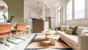 Ein modernes Wohnzimmer mit einer Couch, einem Couchtisch und einem Essbereich mit Stühlen.