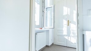 A hallway with a white door, a window, and a radiator. - Nice Room for Longstays @Margareten, Up to 2P (Vienna)