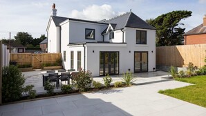 A modern two-story house with a patio, a wooden fence, and a well-maintained garden. - Modern 5-bedroom Retreat Nr Coast (Emsworth)