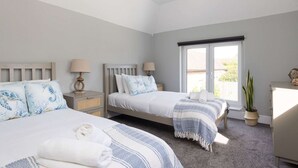 A bedroom with two beds, a window, a plant, and a dresser. - Modern 5-bedroom Retreat Nr Coast (Emsworth)