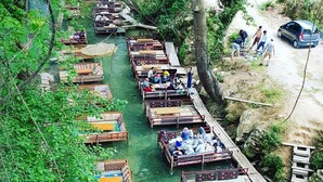 Ein Fluss mit mehreren am Ufer angelegten Holzkähnen.