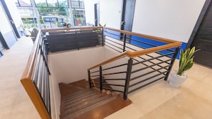A staircase with wooden handrails and metal railings, leading to an upper floor. - The Strype Hotel (Tagaytay)