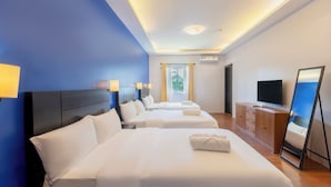 A hotel room with three beds, a TV, a mirror, and a window with curtains. - The Strype Hotel (Tagaytay)