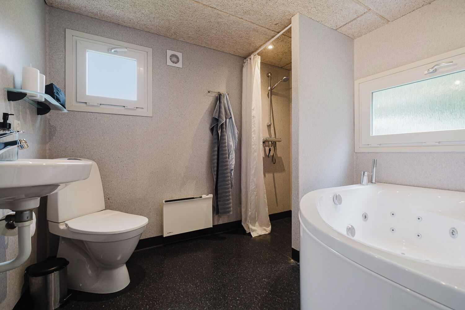 A bathroom with a toilet, sink, shower, and bathtub.
