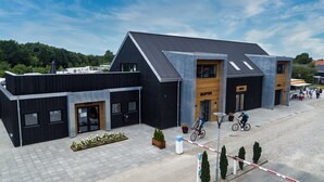 A modern building with a reception area, a café, and a bike parking area. - Ribe Camping (Ribe)