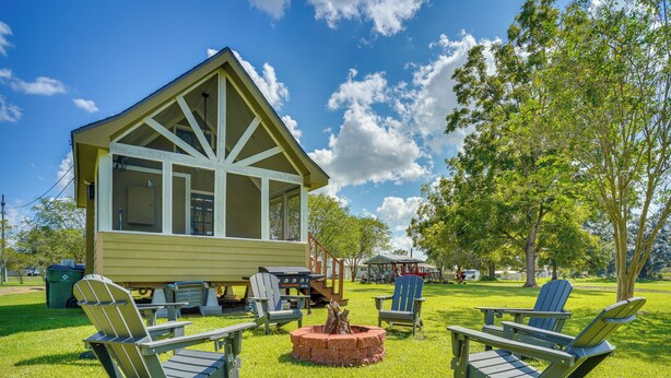 A lodge with a large deck, outdoor seating, and a fire pit. - Cozy Couples Retreat w/ Porch on Bayou Teche! (New Iberia)