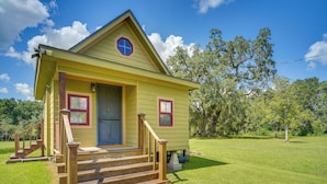 A yellow house with a front porch, wooden steps, and a blue door. - Cozy Couples Retreat w/ Porch on Bayou Teche! (New Iberia)